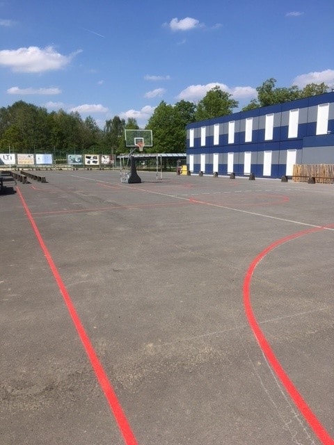 zicht op buitenbasketterrein met mobiel basketdoel